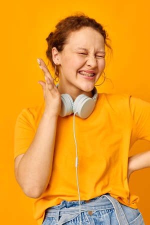 pretty woman grimace headphones music technology yellow background unalteredの写真素材
