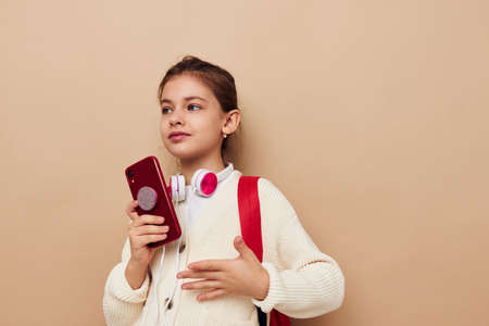 girl with backpack in headphones with phone technologyの写真素材
