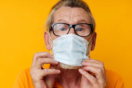 Photo of retired old man medical mask on the face protection close-up isolated background
