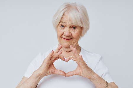 Portrait of an old friendly woman in a white t-shirt cropped viewの写真素材