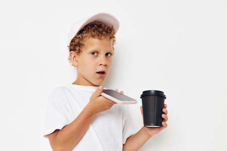 Photo portrait curly little boy what kind of drink is the phone in hand communication lifestyle unalteredの写真素材