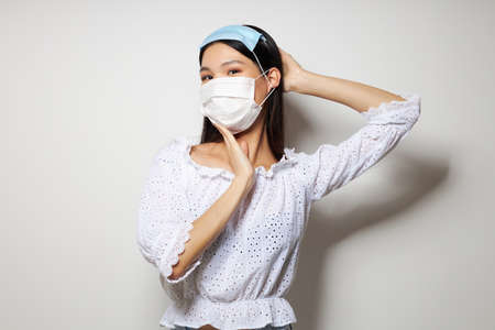 pretty brunette two medical masks on the head protection isolated background unalteredの写真素材