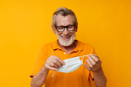 Photo of retired old man with glasses face shield safety isolated backgroundの写真素材