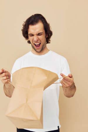 Attractive man paper bag emotions posing Lifestyle unalteredの写真素材