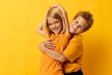 picture of positive boy and girl cuddling fashion childhood entertainment isolated backgroundの写真素材