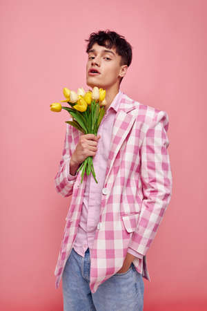 cute guy in a plaid jacket with a bouquet of flowers gift dateの写真素材