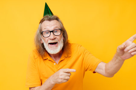 Portrait of happy senior man fun birthday cap on the head monochrome shotの写真素材