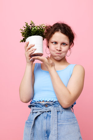 cheerful woman flower in white pot posing emotion Lifestyle unalteredの写真素材