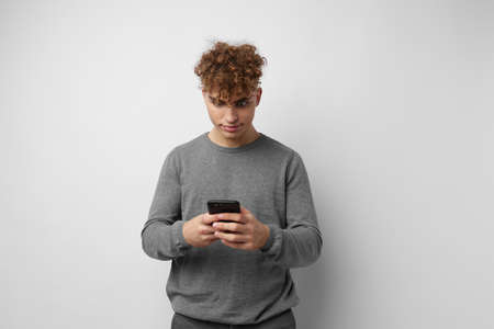 Attractive man with a phone in hand communication light background
