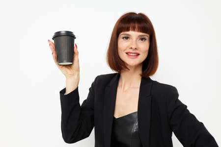 beautiful woman in a black suit a mug with a drink charm Lifestyle unalteredの写真素材