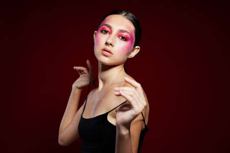 Sexy brunette woman black t shirt pink makeup cosmetics fashion pink background unaltered