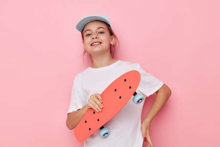 little girl cap in white t-shirt skateboard childhood unalteredの写真素材