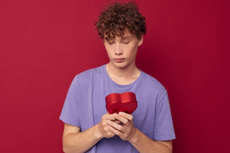 cute curly guy in purple t-shirt heart shaped box giftの写真素材
