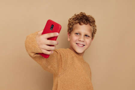 little boy with curly hair red phone technology funの写真素材