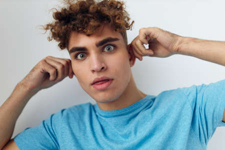 Cheerful guy with curly hair gestures with his handsの写真素材