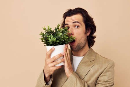 Attractive man with a flower pot in his hands classic style isolated backgroundの写真素材