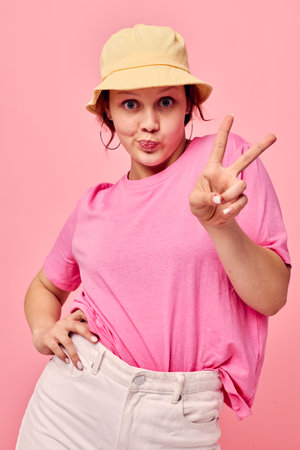 portrait of a young woman fashion clothes hat pink t-shirt decoration posingの写真素材