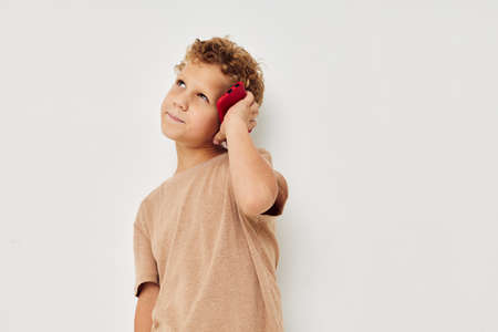 Cheerful cute boy with phone in hands posing technology