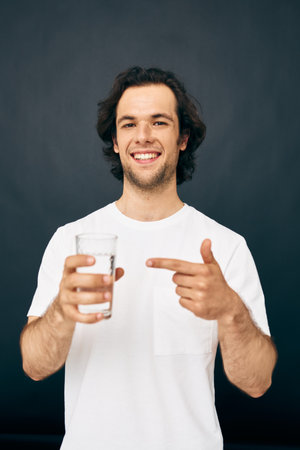 Cheerful man glass of water in his hands emotions posing beige background