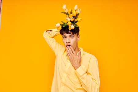 handsome guy in yellow glasses with a bouquet of flowers yellow background unaltered