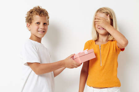 Portrait of cute children gift pink box birthday holiday childhood light backgroundの写真素材