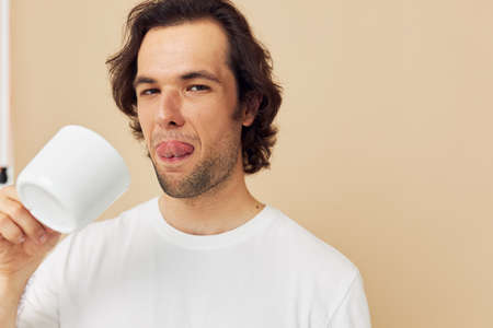 handsome man with a white mug in his hands emotions posing isolated background