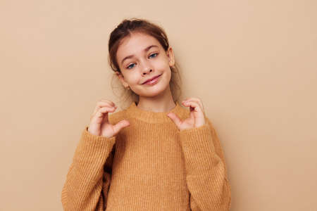 Portrait of happy smiling child girl in sweater posing hand gestures childhood unaltered