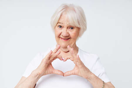 emotional elderly woman smile hand gesture isolated backgroundの写真素材
