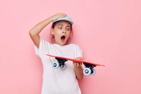 cute girl cap in white t-shirt skateboard Lifestyle unalteredの写真素材