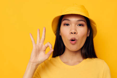 woman in a yellow t-shirt and hat posing emotions isolated background unaltered