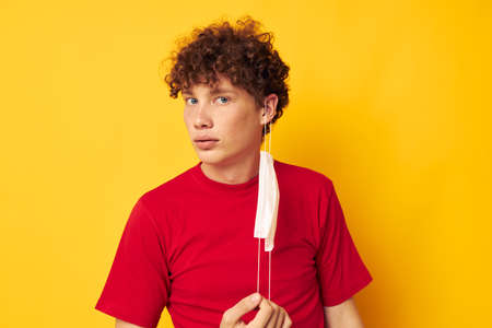 guy with red curly hair in a red t-shirt medical mask protection Lifestyle unaltered