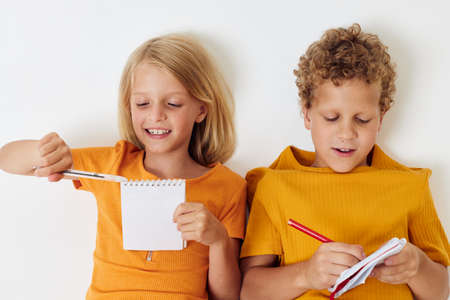two joyful children emotions drawing together notepad and pencils childhood lifestyle unalteredの写真素材