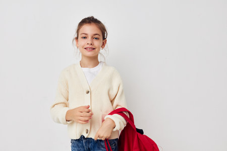 cute schoolgirl with red backpack posing Lifestyle unalteredの写真素材