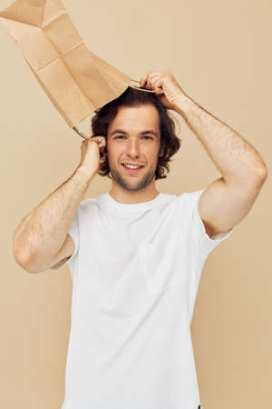 Attractive man in a white T-shirt with paper bag Lifestyle unaltered