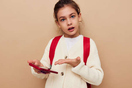 pretty young girl schoolgirl backpack phone in hand childhood unaltered
