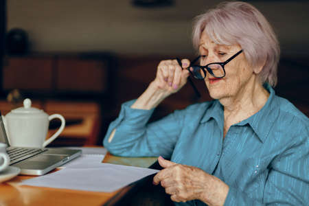 Happy senior woman in a cafe a cup of drink laptop Social networks unaltered