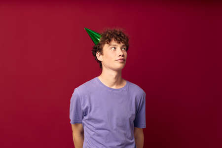 with a cap on his head kinky guy fashion posing hand gestures red background unalteredの写真素材