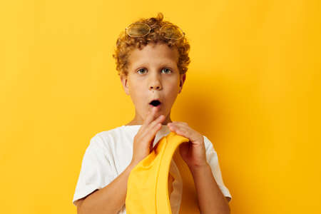 boy in white t-shirt yellow hat posing emotionsの写真素材