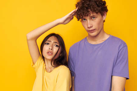 portrait of a man and a woman in colorful t-shirts posing friendship fun isolated background...