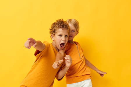 picture of positive boy and girl cuddling fashion childhood entertainment on colored background...