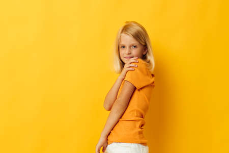 beautiful little girl in a yellow t-shirt smile posing studio childhood lifestyle unalteredの写真素材
