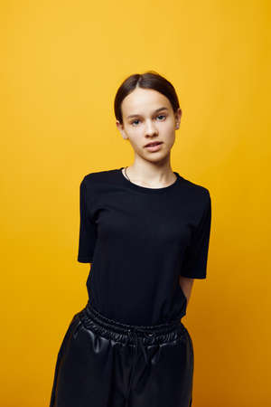 optimistic young woman in a black T-shirt and pants smile isolated background