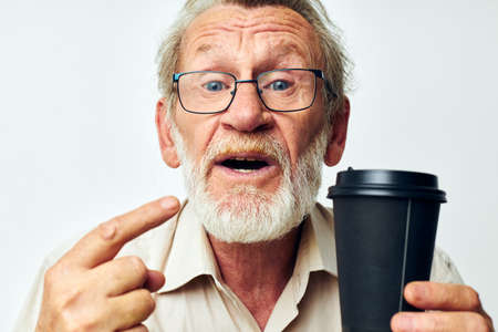Portrait elderly man with a gray beard in a shirt and glasses isolated backgroundの写真素材
