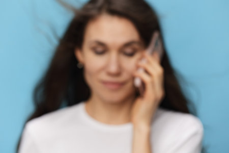 a highly blurred portrait of an unrecognizable woman with a phone in her hands. Photo out of focus