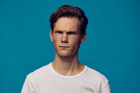 gloomy portrait of a guy in a white t-shirt with an evil faceの写真素材