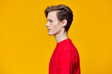 guy in a red T-shirt posing on a yellow background