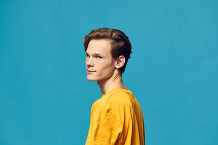 portrait of a guy in a yellow T-shirt looking at the cameraの写真素材