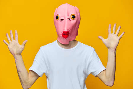 a man in a funny rubber mask shows numbers with gesturesの写真素材