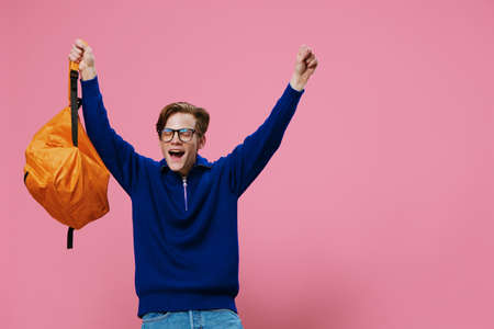 happy, joyful student in glasses rejoices by raising his hands upの写真素材