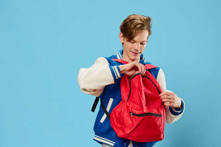 guy student with a red backpack dressed backwards